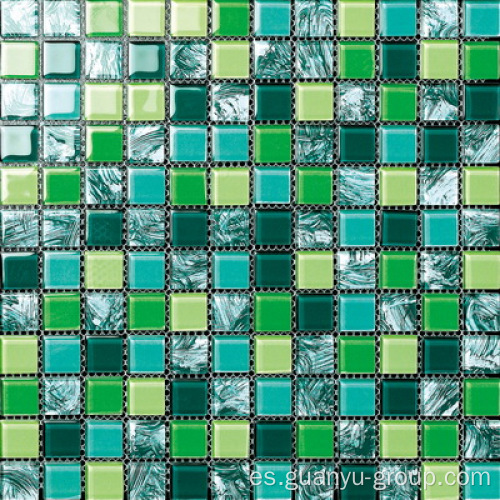 Mano que pinta el mosaico de cristal del color verde